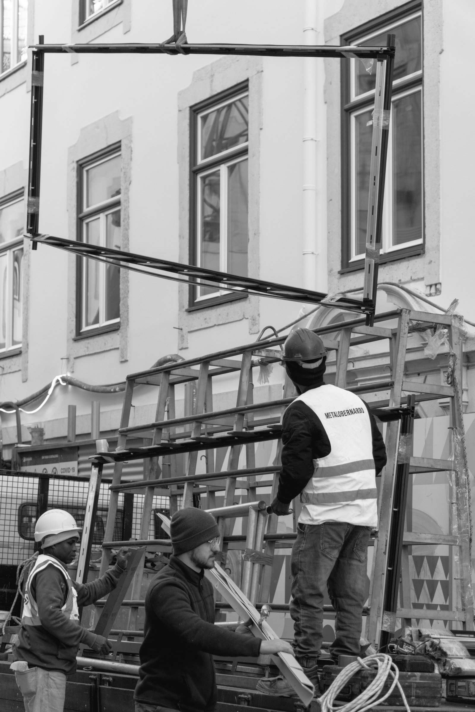 Instaladores colocando un marco de ventana en una fachada